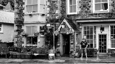 A man smoking outside a Welsh pub on a rainy day
